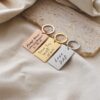 Pack of 3 engraved stainless steel keychains with personalized designs."