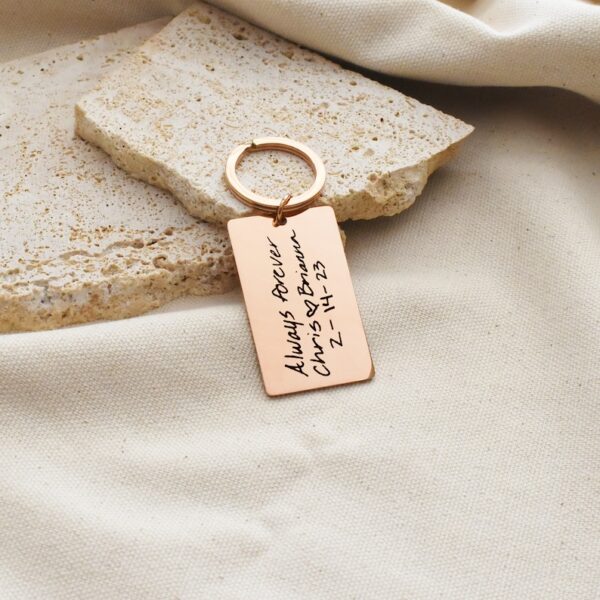 "Pack of 3 engraved stainless steel keychains with personalized designs."