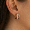 "Woman wearing silver triple hoop earrings with crystal detailing, showcasing elegant and modern jewelry style"